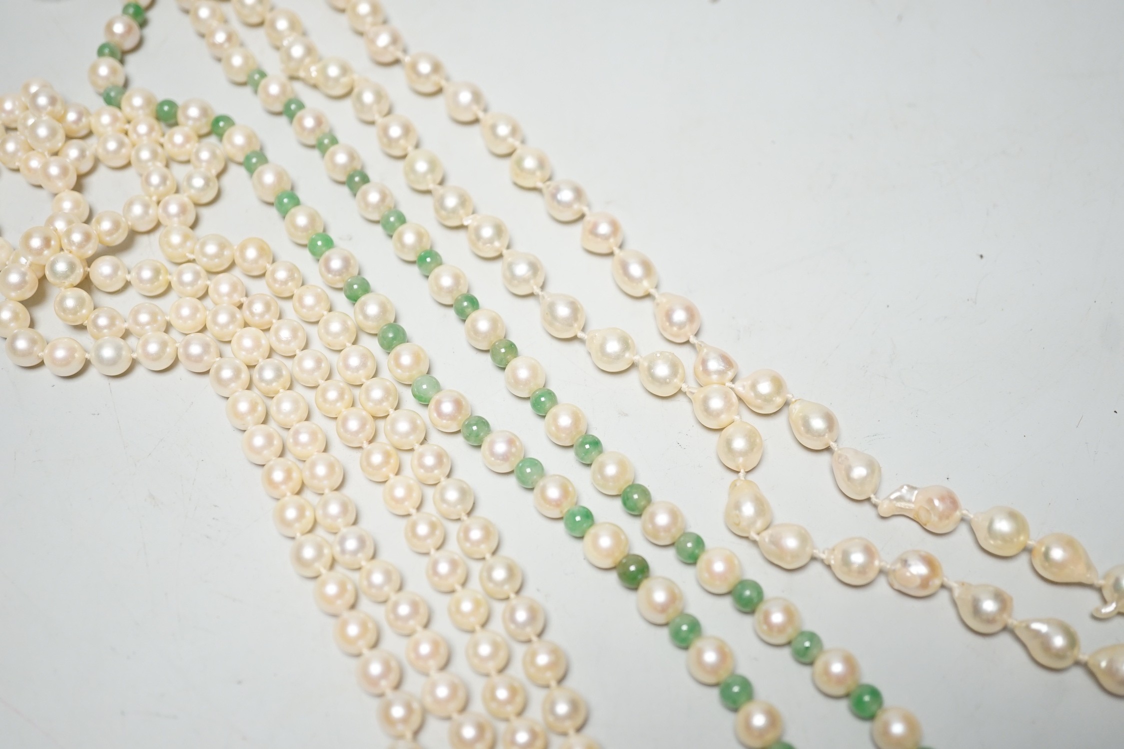 A Mikimoto single strand cultured pearl and green quartz? bead necklace, with white metal and cultured pearl set clasp, 55cm and two other cultured pearl necklaces.